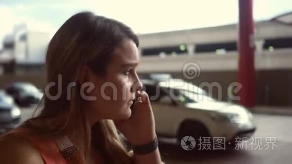 一名妇女在机场接送站等候度假时打电话给出租车司机