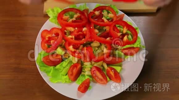 女用手把红椒圈放在盘子里,里面放着生菜和西红柿.短视频