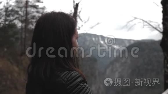 徒步旅行者女士背着背包在山上和山河湖上寻找，女孩在旅途中欣赏大自然的全景