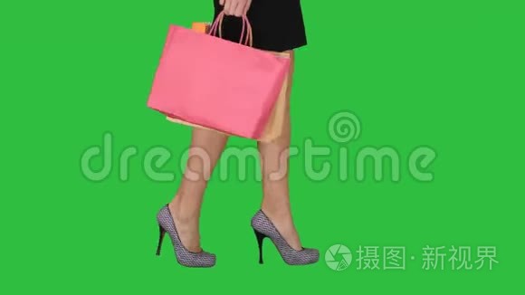 购物女士的步行腿，带购物袋在绿色屏幕上，Chroma键。