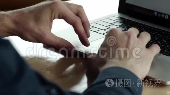 商人的双手，在咖啡馆里坐在木桌旁，可以看到一个在笔记本电脑上工作的人。 讨论