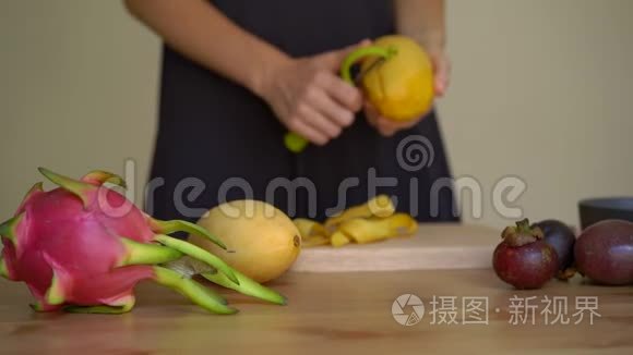 慢镜头拍摄一位年轻女子剥芒果和许多热带水果放在桌子上