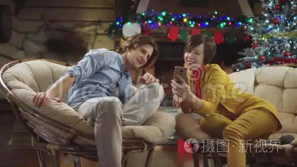 男人和女人在圣诞夜看智能手机视频