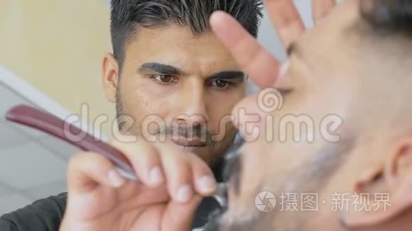 理发店的理发师给他的客户刮脸视频
