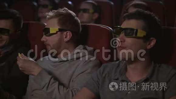 男人朋友在3d电影里吃爆米花。 男人喜欢看电影