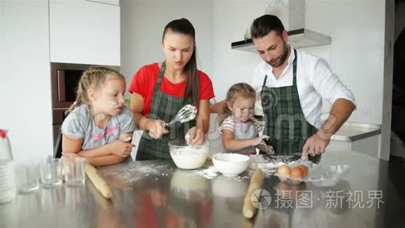 父母教孩子做饭。 他们教孩子们如何烹饪面团。