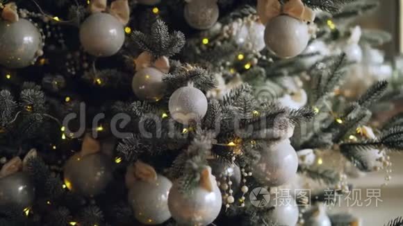 装饰的绿色圣诞树树枝的特写镜头，有美丽的闪亮的球和漂亮的装饰品。 新