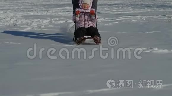 妈妈推着雪橇，后面有一个小女儿，一个三岁的小女孩和妈妈一起走