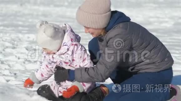 妈妈和女儿在玩雪球，妈妈和一个三岁的女儿在冬天玩雪球，女儿