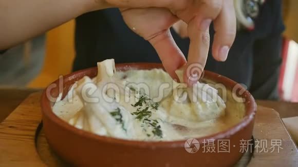 格鲁吉亚菜。 金发碧眼的人在奶油酱里吃Khinkali。 慢动作