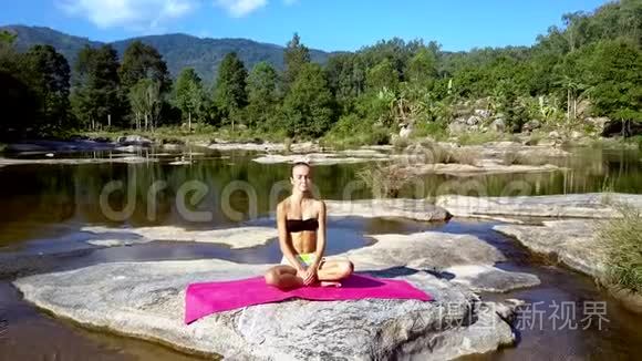 女孩在河边和远山间休息做瑜伽视频