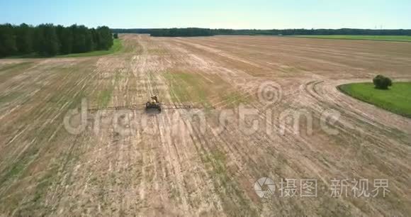 长条驱动的肥料撒布机沿着收获的田野
