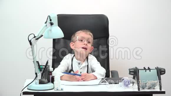 有趣的带大眼镜和听诊器的儿童医生坐在他的办公室里，真正的专业医生