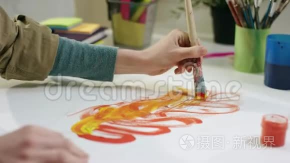 年轻的女艺术家用画笔按桌作画视频