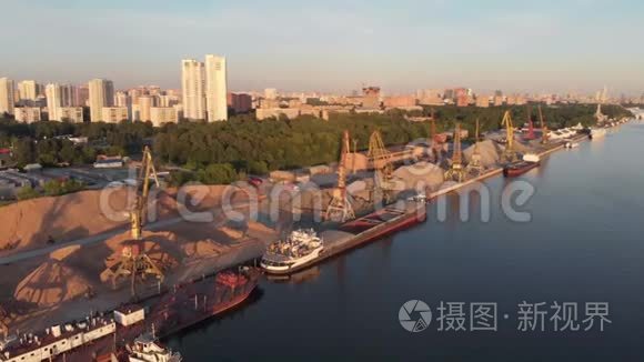 河港全景，船队驳船停泊在河岸旁边的水中。 大波浪河景观