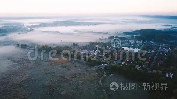 空中录像。 雾蒙蒙的清晨乡村。 小富村被雾蒙蒙的山谷和田野包围着。 道路