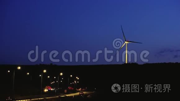 夜间黄昏附近高速公路附近的风车，在交通中有发光的汽车