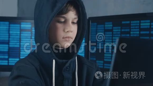 年轻的天才黑客程序员在引擎盖里工作，在数据中心的电脑里充满了显示屏