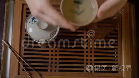 亲密的茶友从木桌上端起绿茶杯视频