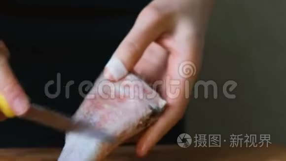 女人用一把小刀在鱼上舀鱼鳞视频