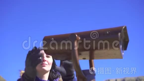 在观景台上的女孩用望远镜看视频