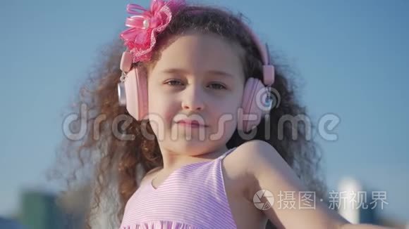 一个卷发可爱的孩子的肖像，一个穿着粉色衣服穿着粉色花朵的白种人小女孩的夏天
