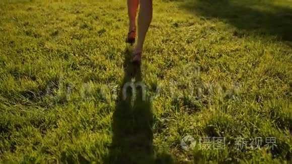女人的脚在公园的草地上奔跑。