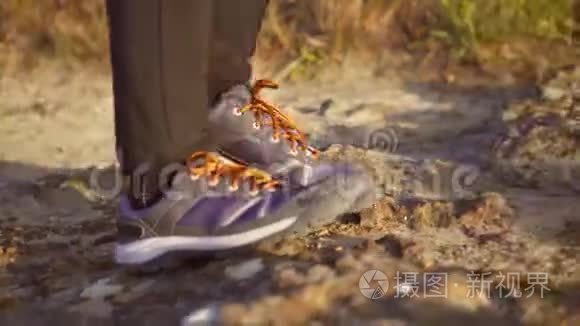 步行者的特写镜头`他的靴子踩在一条带石头的山路上