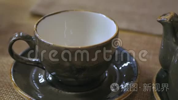 将茶从茶壶倒入老式陶瓷茶杯视频