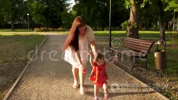 妈妈在公园里的小路上看到了一个学会走路和微笑的小宝宝