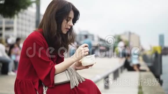 美丽的深色头发的女人夏天在德国街上吃饭，潘射球