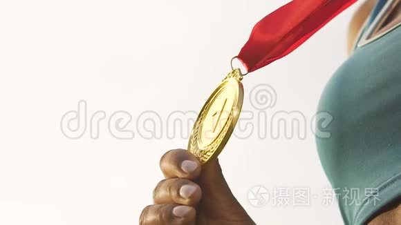 双种族女运动员在镜头前展示金牌，成功和胜利