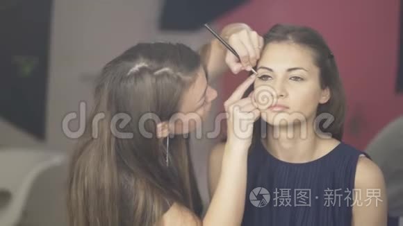 化妆师在模特的脸上涂上化妆霜视频