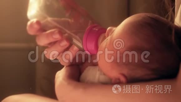 刚出生的女婴从妈妈手里的奶瓶奶嘴`喝
