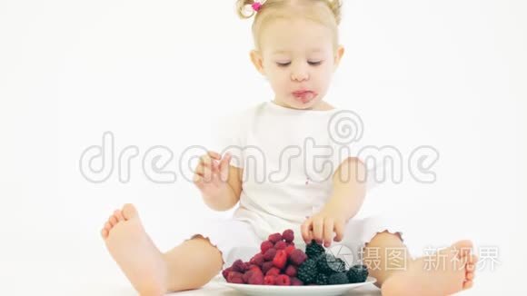 可爱的宝宝在浅色背景下吃浆果视频