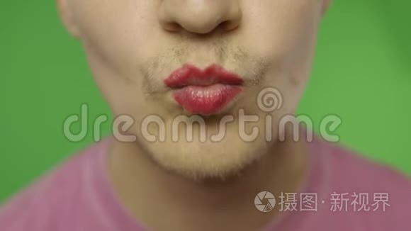 有胡子的男人在镜头上亲吻着涂了漆的嘴唇。 LGBT群体。 变性人
