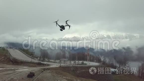 近距离的四架直升机无人机飞行在道路上，山在白色的雾和雪的背景。 股票
