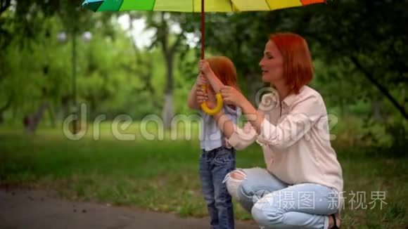 在彩色雨伞下快乐的妈妈和女儿视频