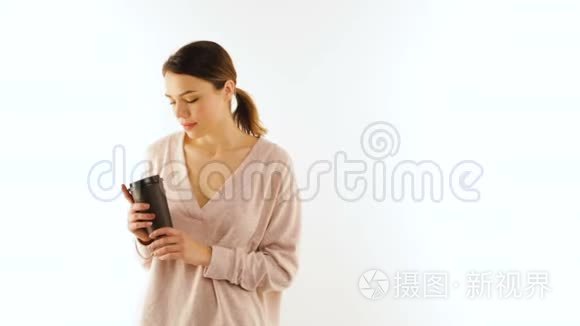 美丽的女孩手里拿着一杯咖啡看着相机，与世隔绝