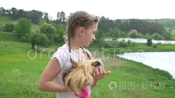 带着她的豚鼠宠物动物的金发女孩。 在外面手持流畅的镜头。 夏天。