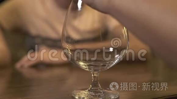 酒保在餐厅的酒吧柜台做鸡尾酒之前，先把冰放在玻璃里。 把酒保关起来