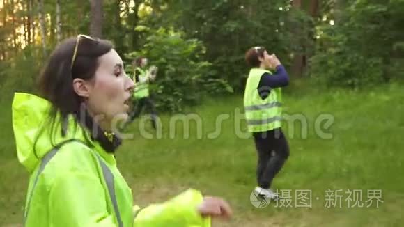 一群志愿者穿着绿色背心在树林里寻找失踪的人