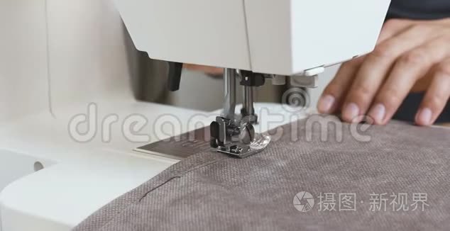 男裁缝工手拿布在缝纫机后面视频