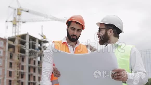 高层建筑施工现场或建筑工地，男建筑工程师与建筑师讨论.. 他们