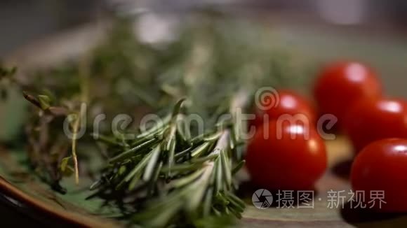 新鲜的迷迭香和美味多汁的红色西红柿躺在厨房的木板特写。 摄像机从左向右移动。