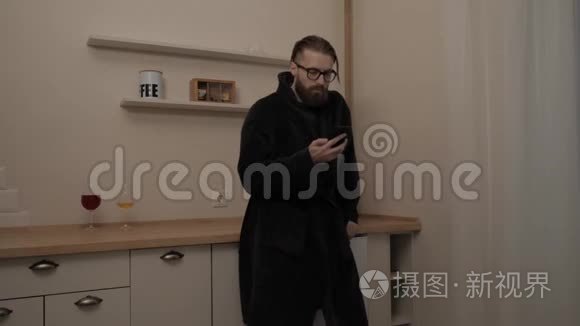 胡子男人用智能手机听音乐视频