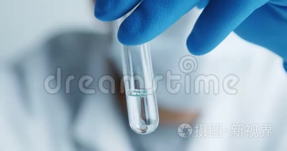 实验室的医务人员用玻璃试管仔细检查血清