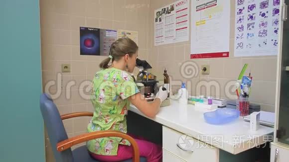 一个穿着绿色连衣裙和白手套的年轻女子透过桌子上的显微镜看着
