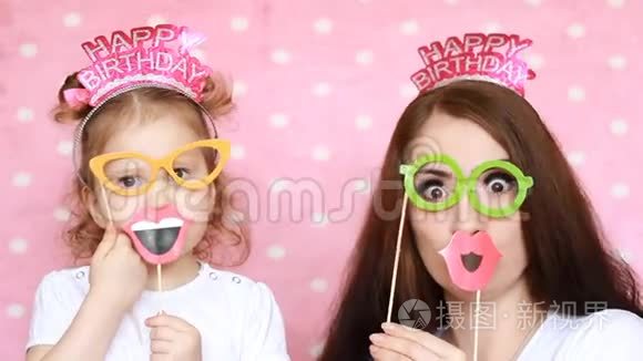 生日快乐。 母女俩戴上眼镜、嘴唇和不同的装饰品来庆祝节日。 这就是