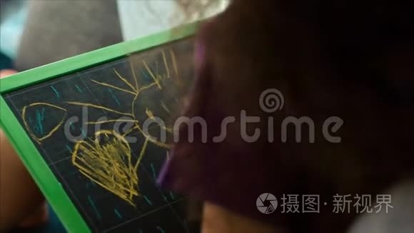艺术家的年轻双手，小儿童艺术家用石墨铅笔绘制画布，坐在桌子上画画布